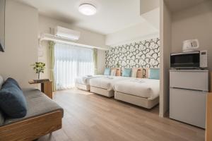 a hotel room with two beds and a couch at ESLEAD HOTEL Namba East in Osaka