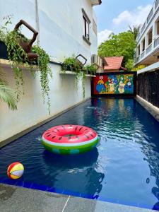 a pool with a red and green raft in the water at Gecko Hostel in Siem Reap