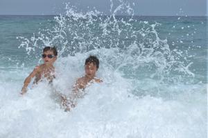 two young boys playing in the waves in the ocean at The Sandscape Fuvahmulah in Fuvahmulah