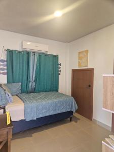 a bedroom with a bed with a green canopy at Sea view house in Utila