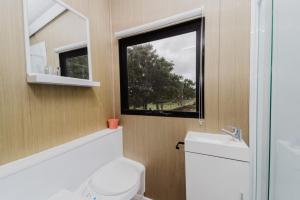 a small bathroom with a toilet and a window at 8 Farm Macadamia Plantation 2 by Tiny Away in Cumbalum