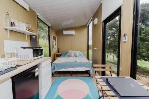 a bedroom in a tiny house with a bed at 8 Farm Macadamia Plantation 2 by Tiny Away in Cumbalum