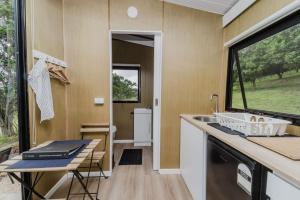 a kitchen in a tiny house with a sink and a window at 8 Farm Macadamia Plantation 2 by Tiny Away in Cumbalum