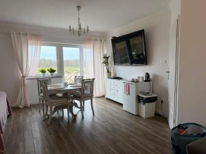 a kitchen and dining room with a table and chairs at Agritourism, family studio in Ładzin