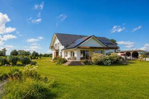 a house on a lawn with a green yard at Agritourism, family studio in Ładzin