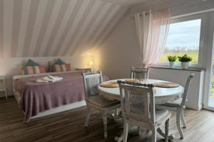 a bedroom with a bed and a table and chairs at Agritourism by the sea in Ładzin