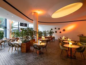 a restaurant with tables and chairs and plants at DoubleTree by Hilton Wroclaw in Wrocław
