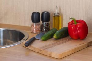 a cutting board with a pepper and cucumbers and a knife at Beckford Tiny House 1 by Tiny Away in Good Hope