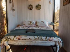 a bedroom with a bed with a green comforter at Blue Gum at Langdale 1 by Tiny Away in Bungendore