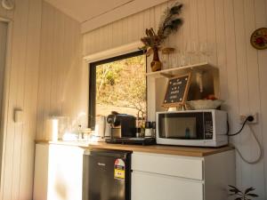 a kitchen with a counter with a microwave and a window at Blue Gum at Langdale 1 by Tiny Away in Bungendore