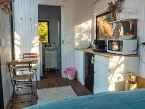 a room with a bed and a kitchen with a microwave at Blue Gum at Langdale 1 by Tiny Away in Bungendore