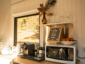 a kitchen with a microwave on a counter with a window at Blue Gum at Langdale 1 by Tiny Away in Bungendore