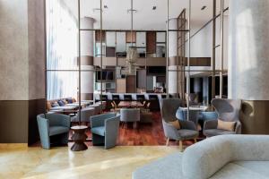 a lobby with blue chairs and a dining room at Doubletree By Hilton Mexico City Santa Fe in Mexico City