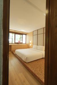 a bedroom with a large white bed and a window at Lavana Villa by Raminten in Yogyakarta +21 photos