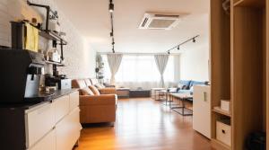 a living room with a couch and a kitchen at CoZzzee Hostel in Singapore