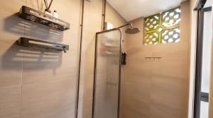 a shower with a glass door in a bathroom at CoZzzee Hostel in Singapore