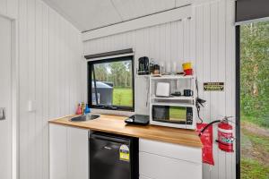 a kitchen with a counter with a microwave and a sink at Clarence Farm Stay by Tiny Away in Maclean