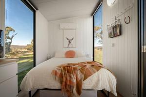 a bedroom with a bed and a large window at Clover at Lexington Park by Tiny Away in Tarlo