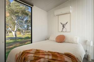 a bedroom with a bed and a large window at Clover at Lexington Park by Tiny Away in Tarlo
