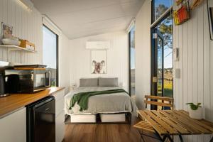 a small bedroom with a bed and a microwave at Myrtle at Lexington Park in Tarlo