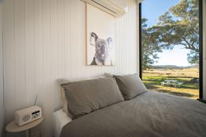 a bed in a bedroom with a picture of a dog at Myrtle at Lexington Park in Tarlo