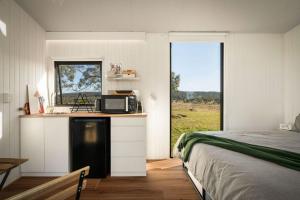a bedroom with a bed and a kitchen with a microwave at Myrtle at Lexington Park in Tarlo +29 photos