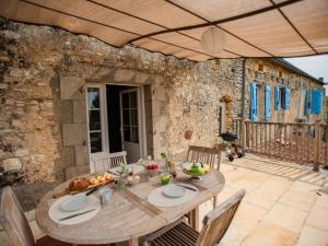 a wooden table with food on a patio at Lavende in Dégagnac