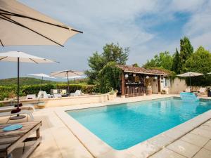 a swimming pool with a gazebo and a house at Lavende in Dégagnac