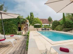 a swimming pool with two chairs and an umbrella at Tournesol in Dégagnac