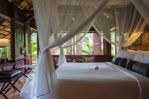 a bedroom with a bed with a mosquito net at The Luang Say Lodge in Pakbeng
