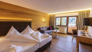 a hotel room with a large bed and a desk at Hotel Plattenhof in Lech am Arlberg