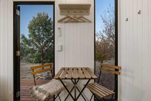 a porch with a wooden table and two benches at The High Country Views Escape by Tiny Away in Table Top