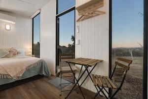 a bedroom with a bed and a table and chairs at The High Country Views Escape by Tiny Away in Table Top
