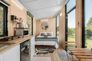 a bedroom in a tiny house with a bed at Hinterland Hideout by Tiny Away in Myocum