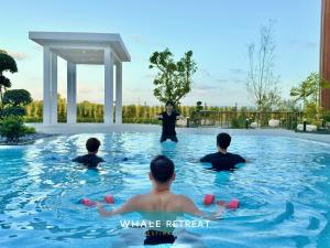 a woman is standing in a swimming pool at Whale Retreat Destination in Hat Yai