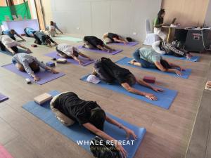 a group of people doing yoga in a room at Whale Retreat Destination in Hat Yai