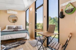 a bedroom with a bed and a table with a laptop at Hinterland Hideout by Tiny Away in Myocum +24 photos