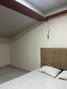 a bedroom with a large bed with a headboard at RAMMANG-RAMMANG HOUSE in Maros