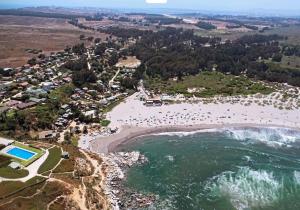 an aerial view of a beach with a group of people at Cabañas y Lodges de Playa Ritoque RITOKAZO in Quintero +77 photos