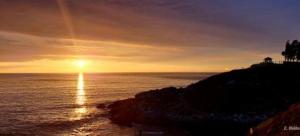 a sunset over the ocean with the sun setting at Cabañas y Lodges de Playa Ritoque RITOKAZO in Quintero