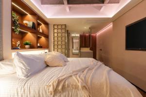 a bedroom with a large bed with a flat screen tv at BoH Collection in Medellín