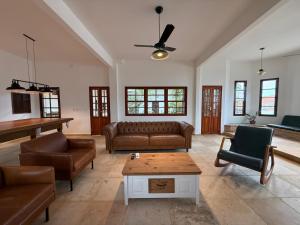 a living room with leather furniture and a piano at Estrela de Mundaú in Trairi