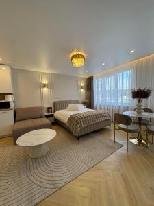 a bedroom with a bed and a couch and a table at Baltic Avenue in Klaipėda