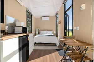 a bedroom with a bed and a desk and a table at Huntingdon House by Tiny Away in Wauchope