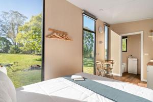 a bedroom with a bed and a large window at Huntingdon House by Tiny Away in Wauchope