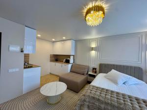a bedroom with a bed and a couch and a table at Baltic Avenue in Klaipėda
