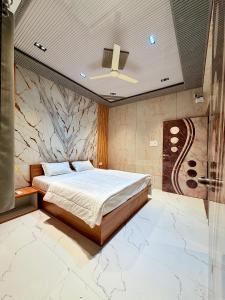a bedroom with a bed and a marble wall at Saiprasad suite & stay in Ellora