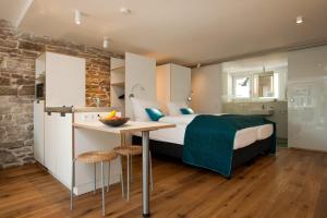 ein Schlafzimmer mit einem Bett und einem Tisch sowie eine Küche in der Unterkunft 1463 Apartmenthaus in Karlsruhe
