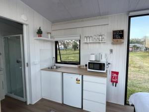 a small kitchen with a sink and a microwave at Little Argyle Tiny House by Tiny Away in Coonabarabran +30 photos
