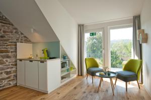 a living room with two chairs and a table at 1463 Apartmenthaus & Restaurant in Karlsruhe